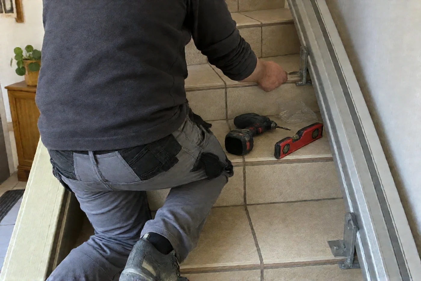 Installateur qui fixe le rail d'un monte-escalier (Sainte-Maxime, Var)